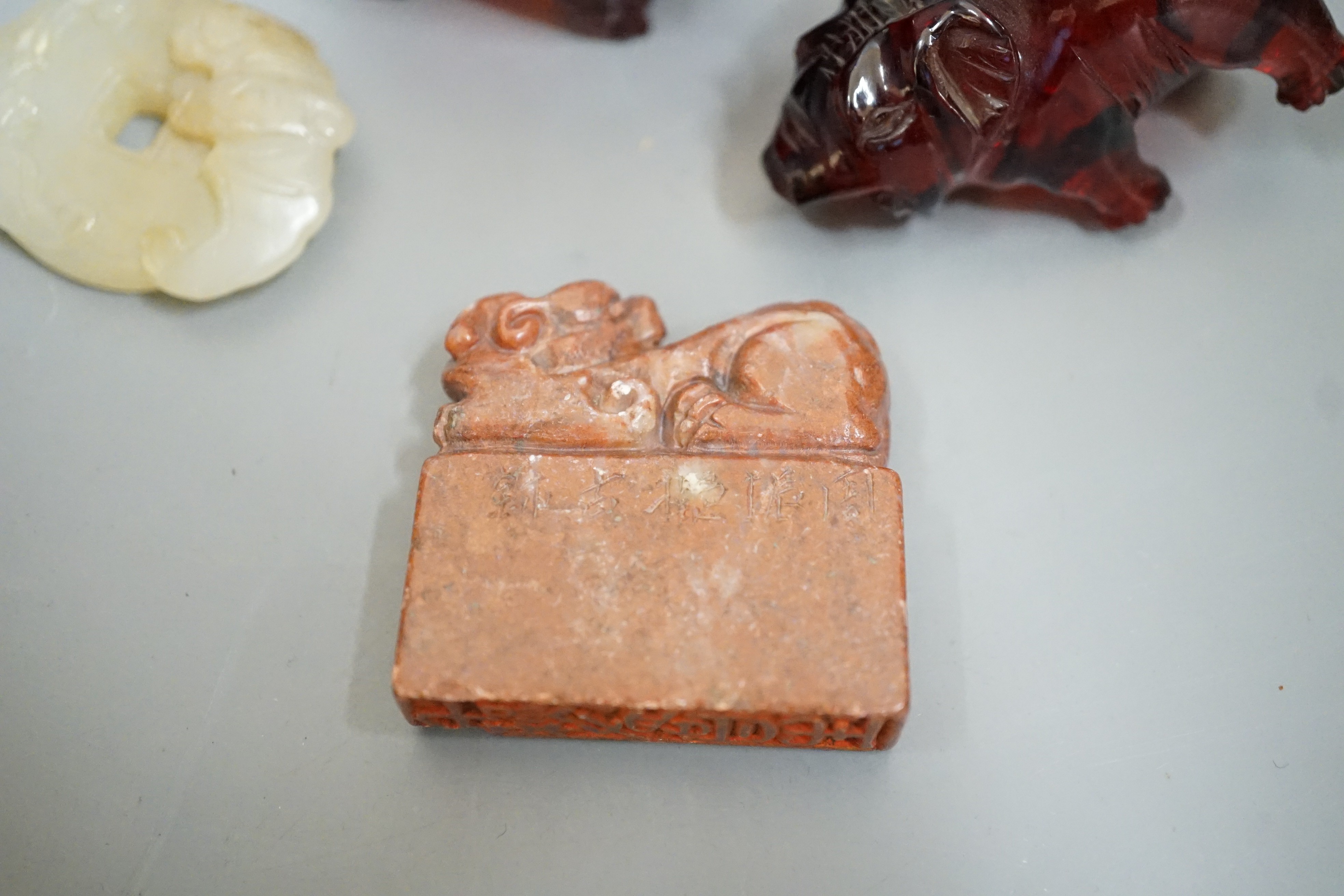 A Chinese Jade bi disc, two cherry amber ox and a soapstone seal
